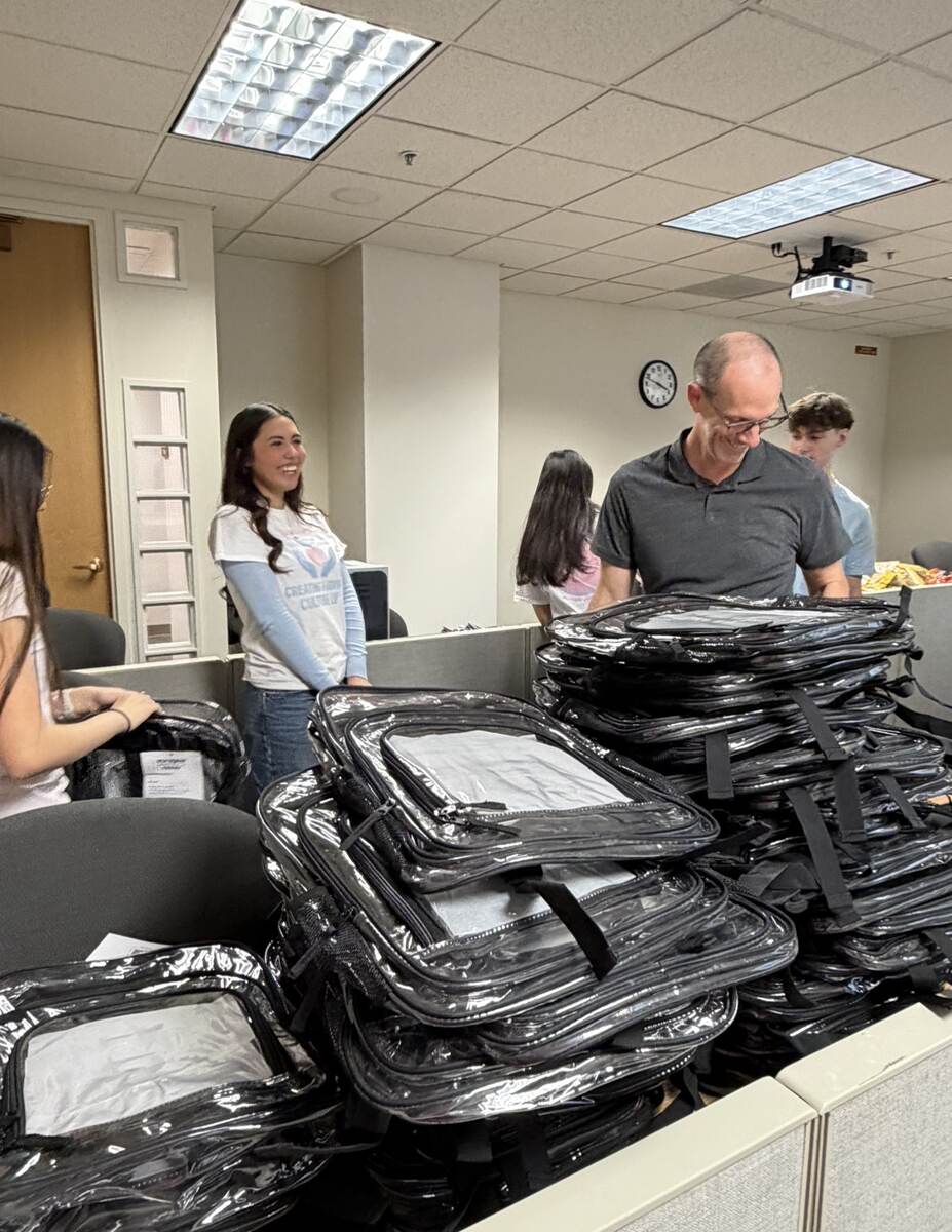 Community partners and volunteers preparing backpacks