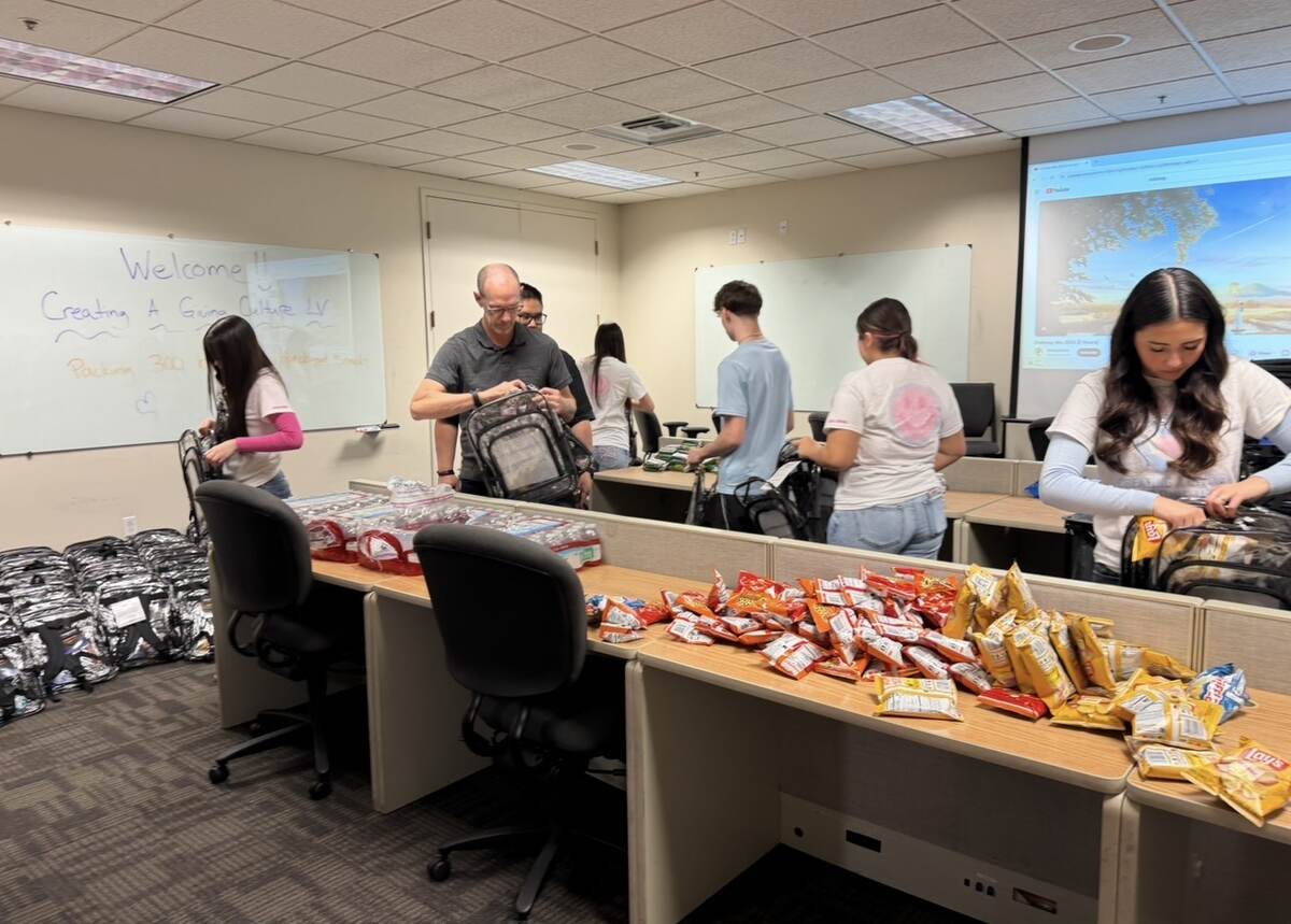 Volunteers filling backpacks with snacks and essential supplies